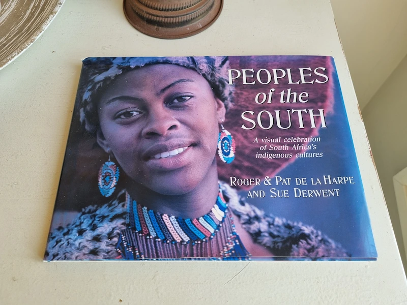 A book titled African Women of the South displayed at Humbi Farm in Mozambique, associated with a retreat setting, featuring themes of Southern African women, culture, and identity