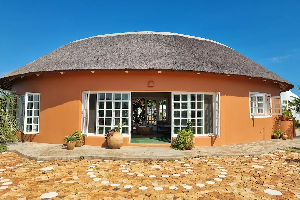 Main lodge at Humbi Farm in Mozambique, featuring rustic tropical architecture surrounded by lush greenery and a peaceful natural landscape.